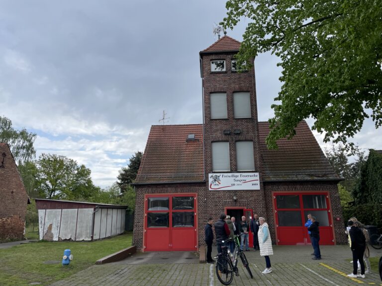 Am Feuerwehrgerätehaus in Saspow/Zaspy versammeln sich Bürgerinnen und Bürger vor der Freiwilligen Feuerwehr Saspow zum Ortsteilrundgang mit Eike Belle.