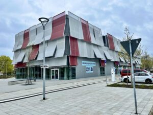 Das Gründerzentrum Startblock 2 in Cottbus zeigt eine moderne Fassade mit roten und weißen Lamellen vor dem Eingang am Siemens-Halske-Ring.