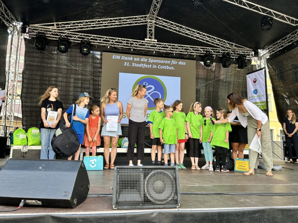 Bei der Ehrung auf dem 31. Stadtfest in Cottbus stehen Katy Marchant, Diane Greene, Alix West Lefler und Mila Stauffer mit Kindern auf der Bühne.