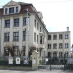 Historisches Gebäude in Cottbus mit Aushängen im Hof zur Vortragsreihe von Diana Marwitz über Nahrungsergänzungsmittel und Gesundheit der Verbraucherzentrale.