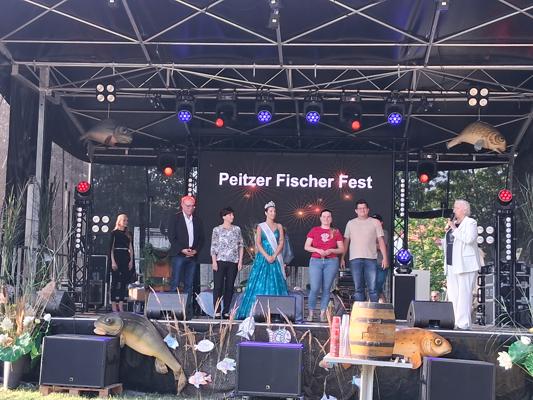 Bei der Eröffnung des 70. Peitzer Fischerfestes stehen mehrere Gäste auf der Bühne im Volkspark, begleitet von Lichtshow und Festprogramm.