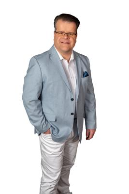 Bei Sommertanz mit Ronny Gander in Guben steht ein Mann im hellblauen Sakko und weißer Hose für einen fröhlichen Tanznachmittag bereit.