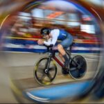 Im Lausitz Velodrom Cottbus sprintet ein Bahnradsportler bei der Europameisterschaft der U19 und U23 unter dem UEC-Logo über die Piste.