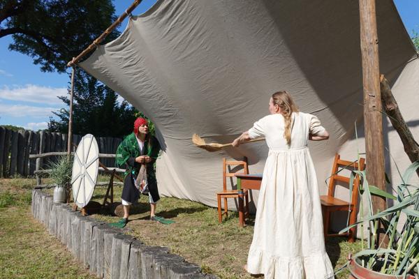 Beim 6. Slawischen Märchenfestival spielen zwei Darsteller unter einem großen Tarp eine Szene im Freien und versetzen Gäste in Märchenwelten.