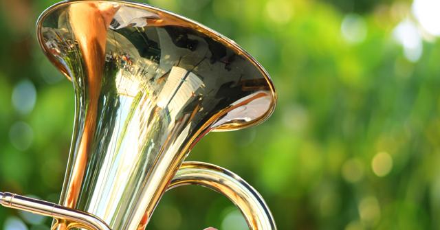 Eine glänzende Posaune vor grünem Hintergrund verweist auf den Landesposaunentag 2026 in Lübben und das musikalische Programm der EKBO.
