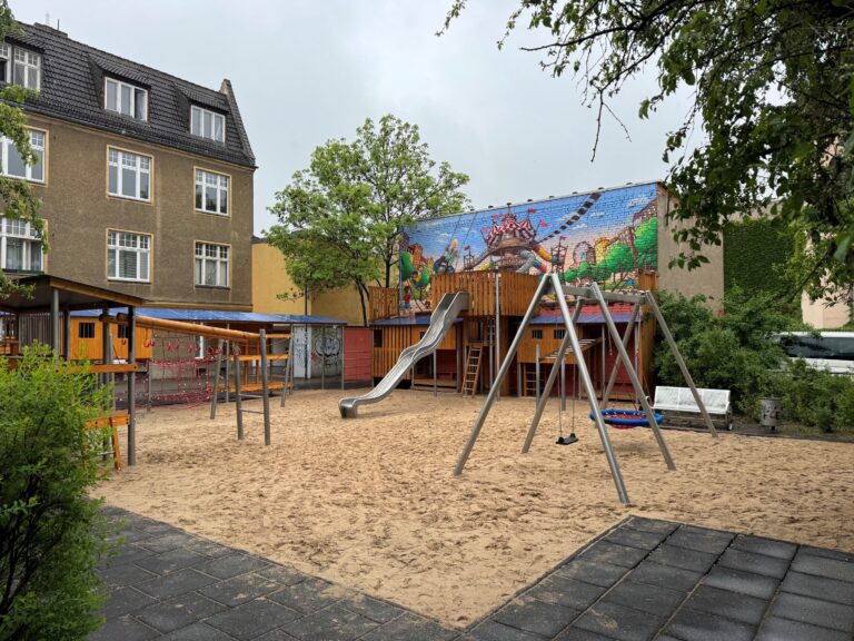 In der Cottbuser Tiegelgasse ist ein neuer Weltspielplatz mit Sandfläche, Rutsche, Kletternetz und farbigem Wandbild im Innenhof entstanden.