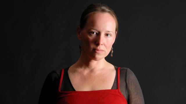 In einem schlichten Porträt blickt Yvonne Zitzmann vor dunklem Hintergrund ruhig in die Kamera und verweist auf „Die geteilte Schuld“.