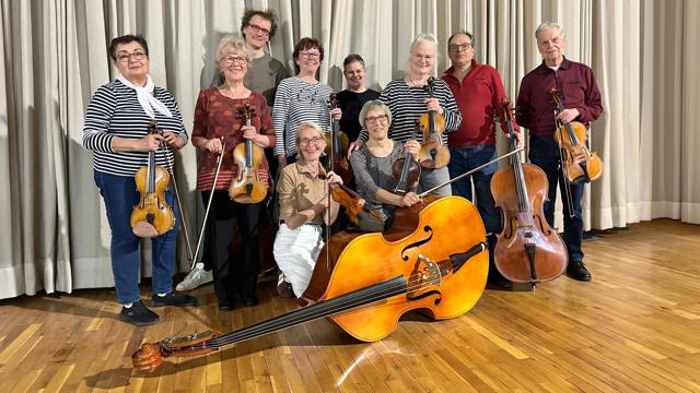 Beim Konzert des Orchesters der Frankfurter Musikfreunde steht eine kleine Streicherbesetzung vor Vorhängen und bereitet die musikalische Reise vor.