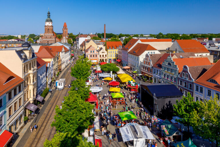 Beim 33. Cottbuser Stadtfest füllt sich der Altmarkt mit Bühnen, Ständen und Besuchern zwischen historischen Häusern in Cottbus/Chóśebuz.