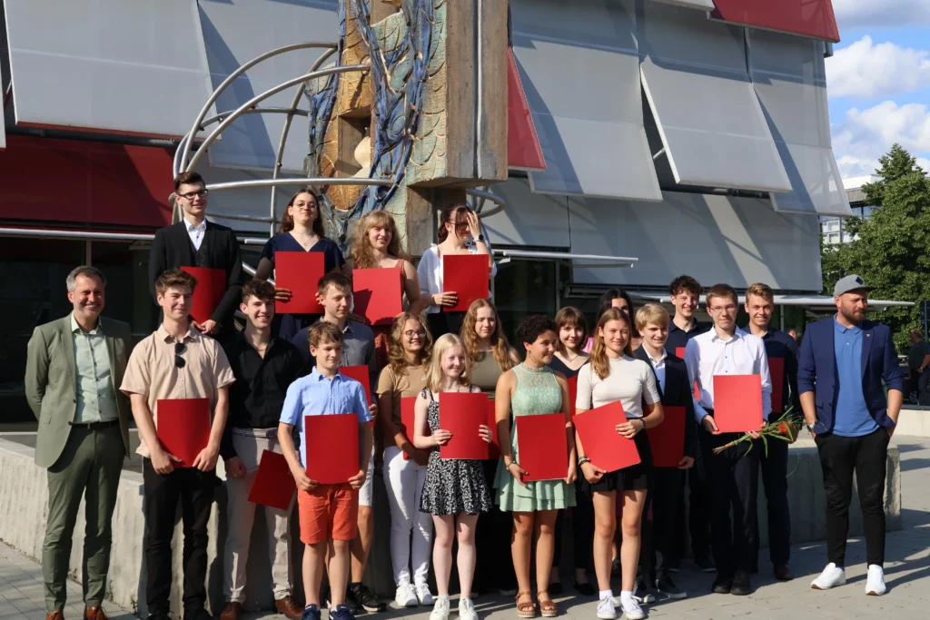 Eintragung in die Ehrenchronik der Stadt Cottbus am 16. Juli 2024 – Gruppenfoto der Geehrten mit Urkunden vor dem Gründungszentrum Cottbus