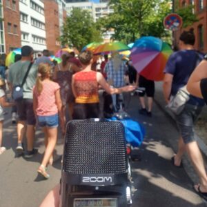 Menschen auf der Straße mit Bunten Regenschirmen, ein Mikrophon in dem Vordergrund