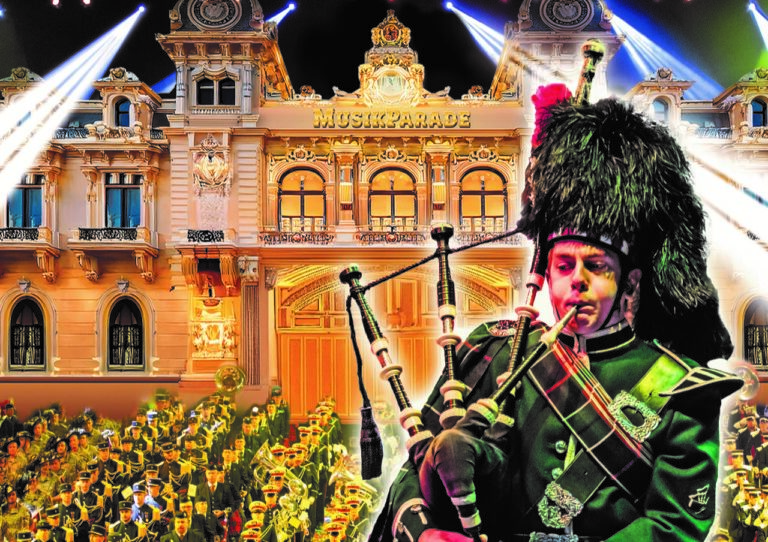 Ein Dudelsackspieler in Uniform spielt vor einer festlich beleuchteten Fassade mit dem Schriftzug „MUSIKPARADE“.