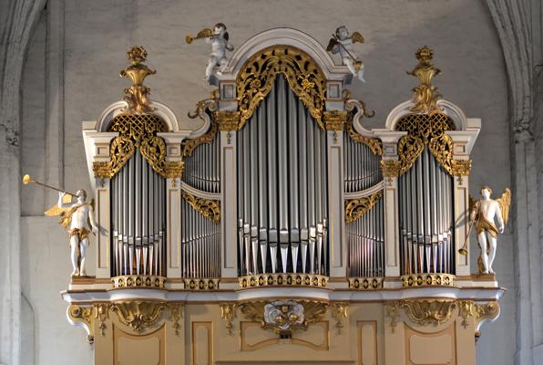 Die reich verzierte Orgel zeigt silberne Pfeifen, goldene Schnitzornamente und mehrere Engelplastiken an der Kirchenwand.