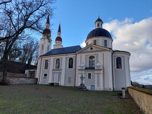 Beim Chorkonzert in Neuzelle steht die weiße historische Kirche im Mittelpunkt und verweist auf musikalische Frühlings- und Sommerstimmung.