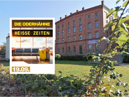 Vor einem roten Backsteingebäude steht ein Plakat zu „Die Oderhähne – Heiße Zeiten“ mit dem Datum 19.09.