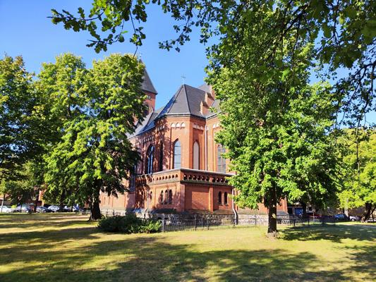 Vor der Kath. Kirche St. Johannes Baptist in Cottbus kündigt das Jubiläumskonzert 25 Jahre Kammerorchester Fürstenwalde einen festlichen Anlass an.