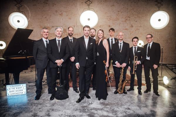 Zum Programm Strangers in the Night posieren Marc Secara, Elwood Francis, Clare Waight Keller und Reeves Gabrels live mit dem Orchester in Cottbus.