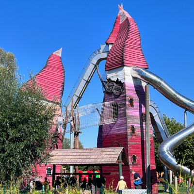 Beim Wasserfest im IRRLANDIA ragen bunte Türme mit langen Rutschen in den Himmel, während Besucher den MitMachPark erkunden.